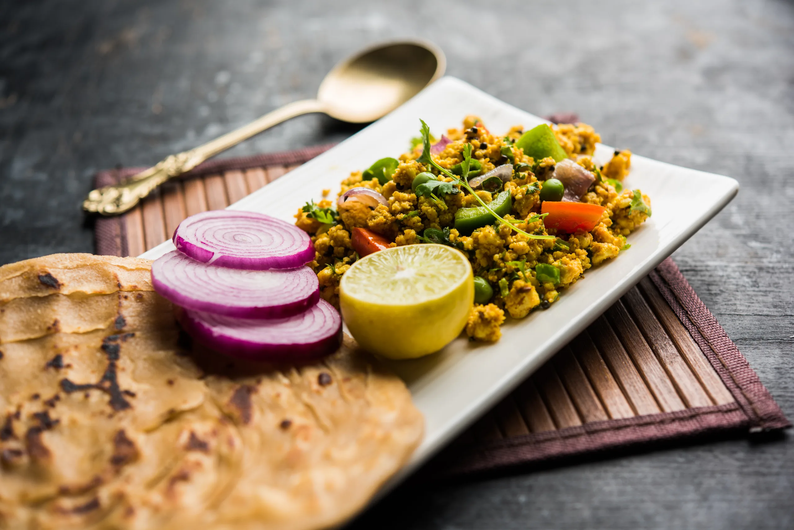 Paneer Bhurji, mildly spiced cottage cheese scramble and served with roti or laccha paratha, selective focus