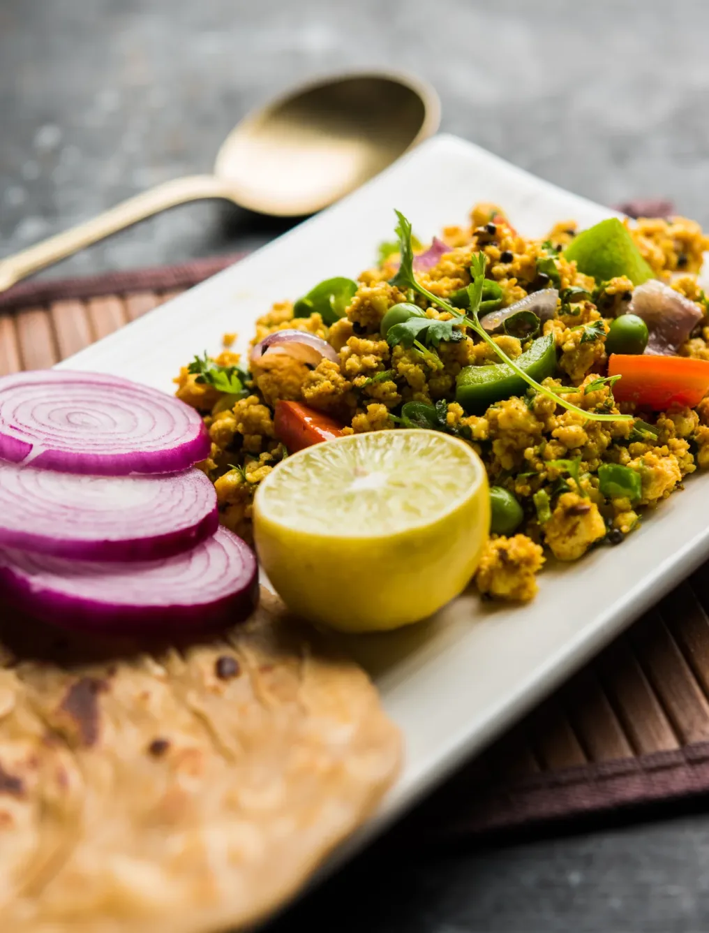 Paneer Bhurji, mildly spiced cottage cheese scramble and served with roti or laccha paratha, selective focus